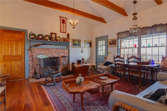 living room with an inviting chandelier, wood-type flooring, high vaulted ceiling, a brick fireplace, and beamed ceiling