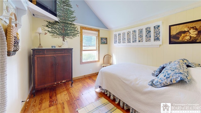 bedroom featuring light hardwood / wood-style flooring and lofted ceiling