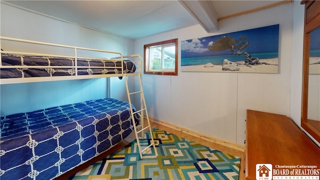 bedroom featuring beamed ceiling and hardwood / wood-style floors