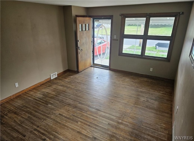 unfurnished room featuring dark hardwood / wood-style flooring and plenty of natural light