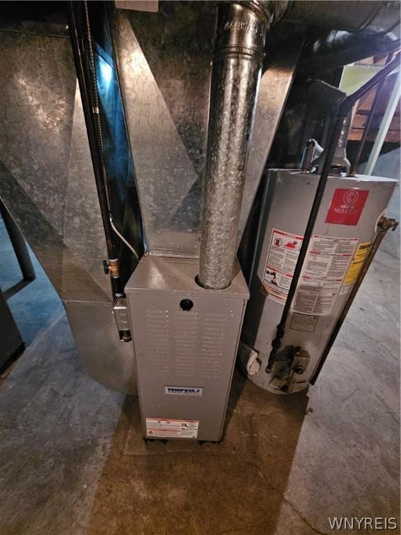 utility room featuring heating unit and gas water heater