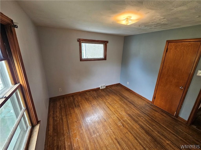 empty room with hardwood / wood-style floors and a textured ceiling