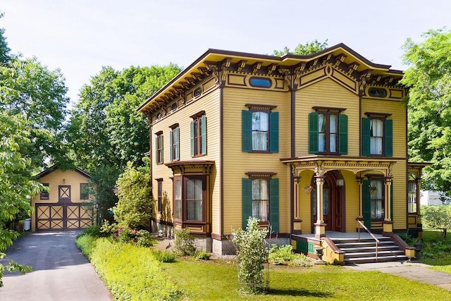 73 Elm St, Otsego, NY 13326 - italianate-style house with driveway, an outbuilding, and covered porch