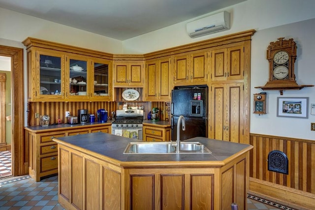 73 Elm St, Otsego, NY 13326 - kitchen with a wall unit AC, a sink, stainless steel range with gas cooktop, freestanding refrigerator, and brown cabinetry