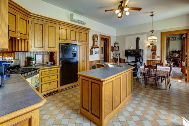 kitchen featuring ceiling fan, black fridge, light tile floors, sink, and stainless steel gas range