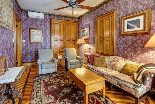 73 Elm St, Otsego, NY 13326 - living area with a wall unit AC, baseboards, wallpapered walls, a ceiling fan, and wood finished floors