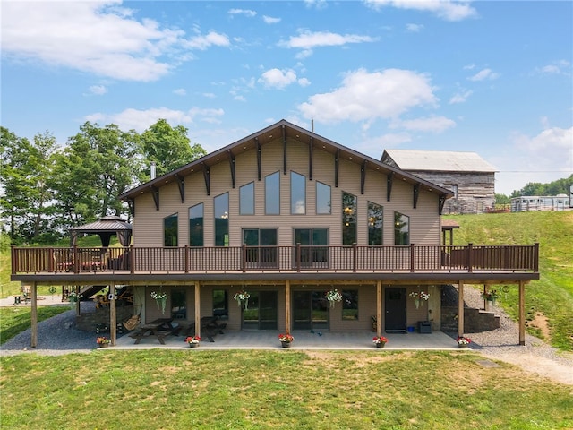 rear view of house featuring a lawn, a patio, and a wooden deck