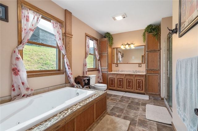 full bathroom with plus walk in shower, vanity, and toilet