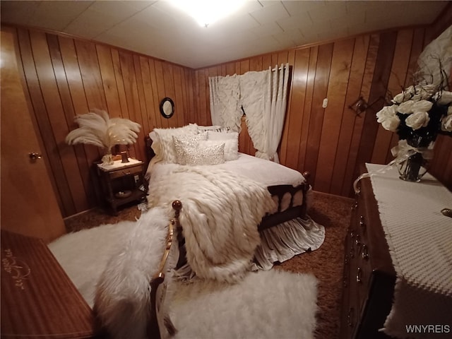 bedroom featuring carpet and wooden walls