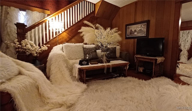 living room with lofted ceiling and wooden walls