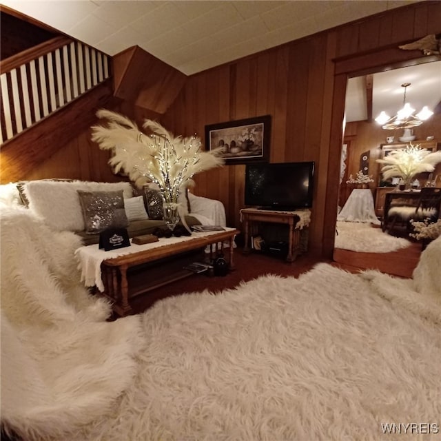 living room with lofted ceiling, wooden walls, and a notable chandelier