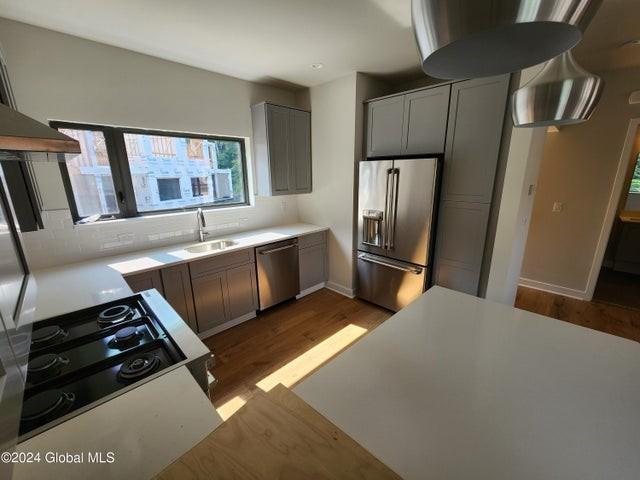 kitchen with gray cabinetry, sink, dark hardwood / wood-style floors, and appliances with stainless steel finishes