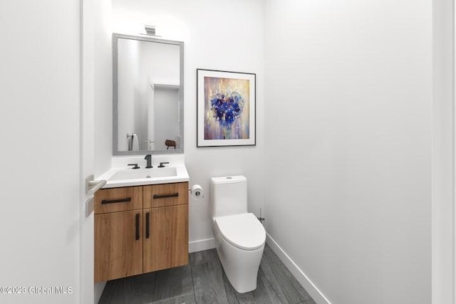 bathroom featuring vanity, toilet, and wood-type flooring