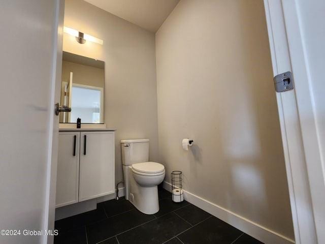 bathroom with tile patterned flooring, vanity, and toilet