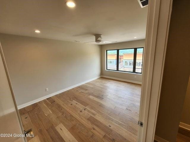 empty room featuring light wood-type flooring and ceiling fan