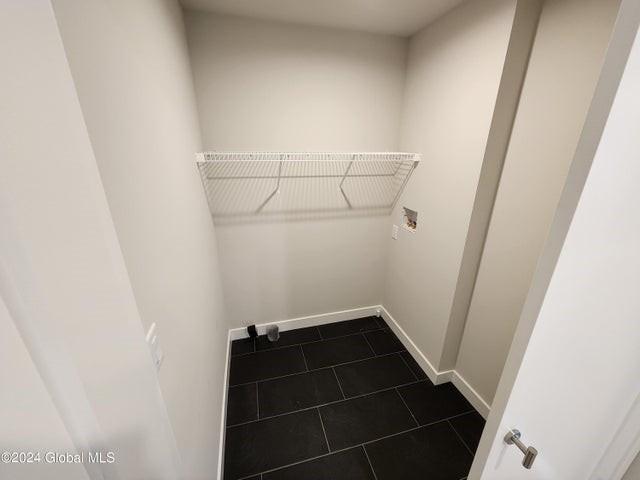 laundry area featuring washer hookup and dark tile patterned floors