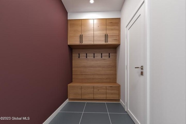 mudroom with dark tile patterned flooring