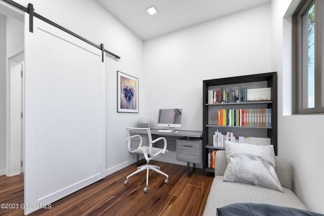 office space featuring a barn door and dark hardwood / wood-style flooring