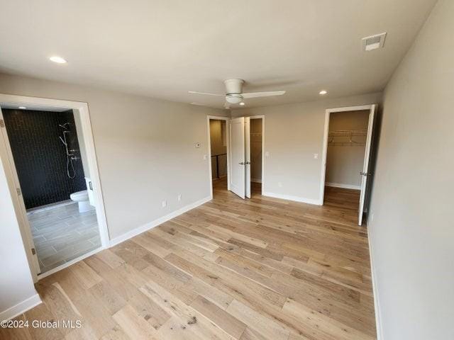 empty room with ceiling fan and light hardwood / wood-style flooring