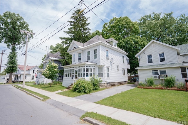 view of front of home featuring a front lawn and a sunroom