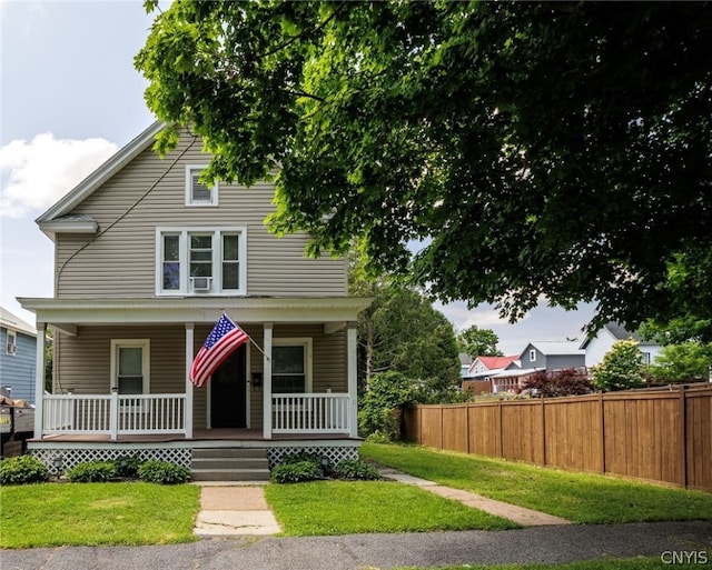 view of front of property featuring covered porch, cooling unit, and a front yard