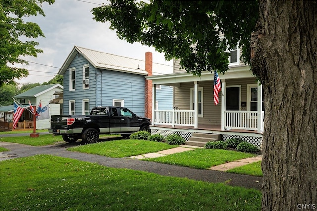 view of front of property featuring covered porch and a front lawn