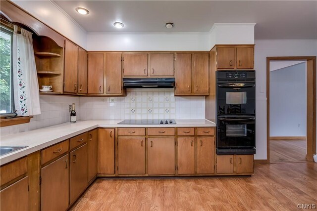 kitchen with backsplash, light hardwood / wood-style flooring, black appliances, and ornamental molding