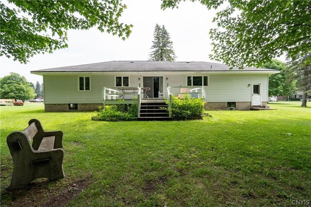 rear view of property featuring a lawn and a wooden deck