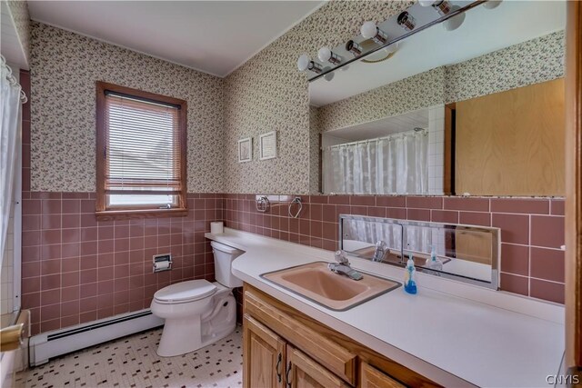 bathroom with tile patterned floors, vanity, baseboard heating, tile walls, and toilet