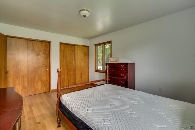 bedroom featuring multiple closets and light hardwood / wood-style floors