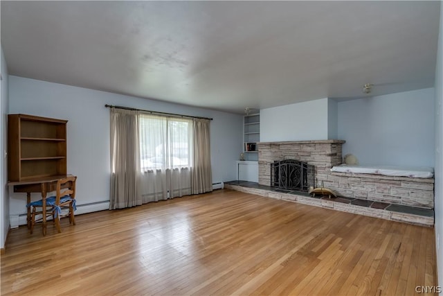 unfurnished living room with a fireplace, a baseboard radiator, and light hardwood / wood-style floors