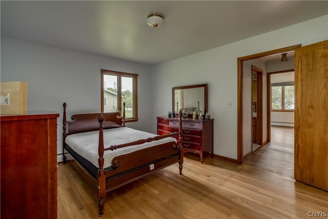 bedroom featuring light hardwood / wood-style floors and a baseboard heating unit