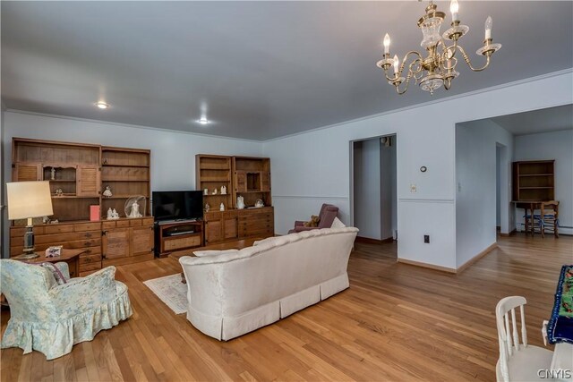 living room featuring ornamental molding, light wood-type flooring, and an inviting chandelier