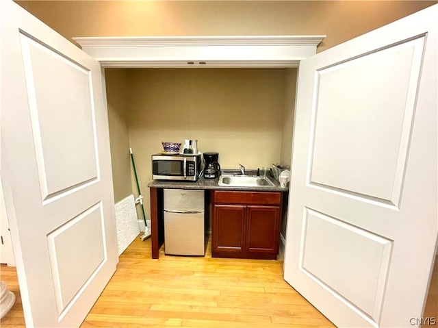 kitchen with sink, light hardwood / wood-style flooring, and white fridge