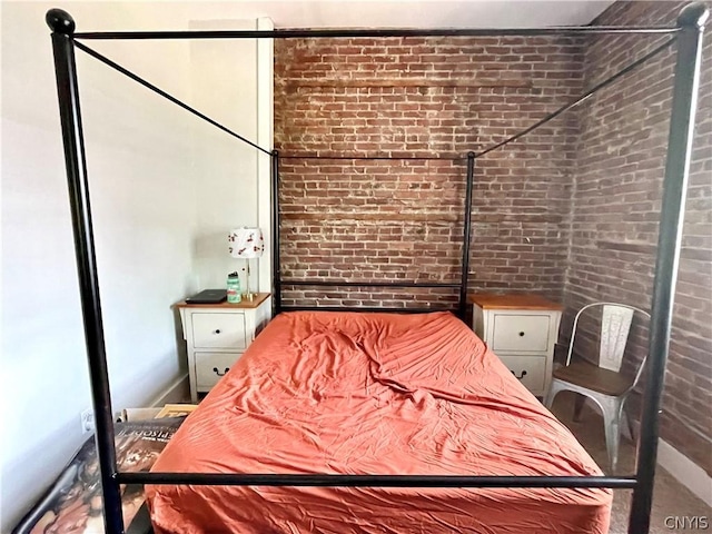 bedroom featuring brick wall