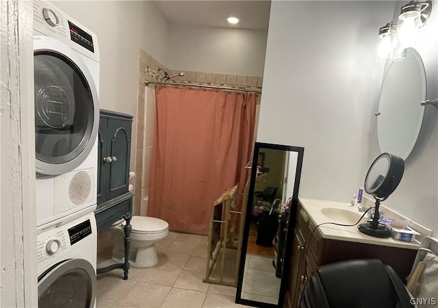 bathroom featuring toilet, curtained shower, stacked washer and dryer, tile patterned floors, and vanity