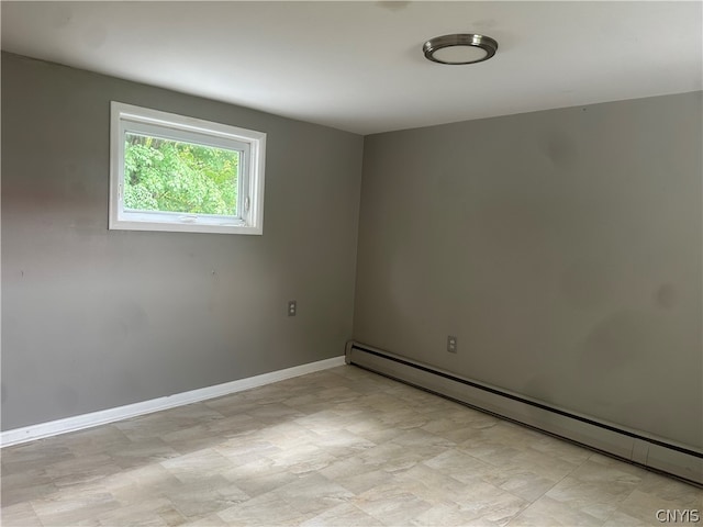 empty room featuring a baseboard heating unit and light tile floors