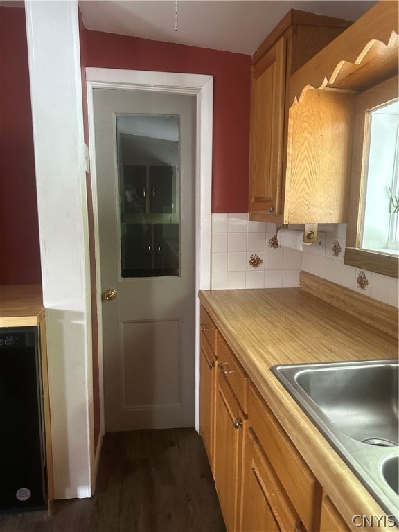 kitchen featuring tasteful backsplash, dark hardwood / wood-style floors, and black dishwasher