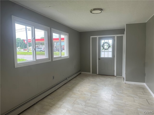 tiled entrance foyer featuring a baseboard heating unit and plenty of natural light