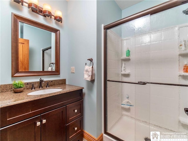 bathroom featuring vanity and a shower with door