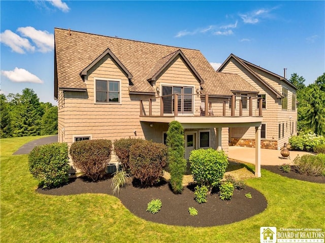 view of front of home featuring a balcony, a front lawn, and a patio