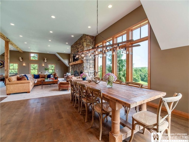 dining room featuring hardwood / wood-style floors and a stone fireplace