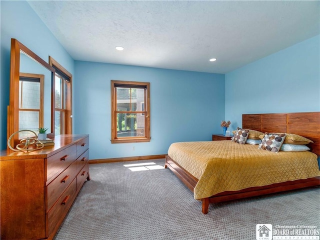 bedroom with light colored carpet and a textured ceiling