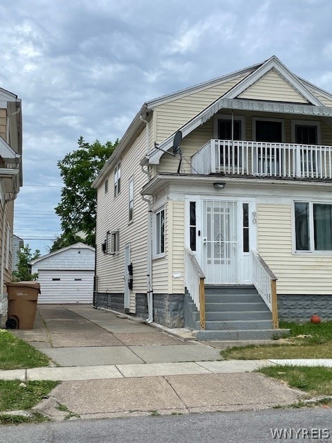 view of front of property with a balcony, a garage, and an outdoor structure