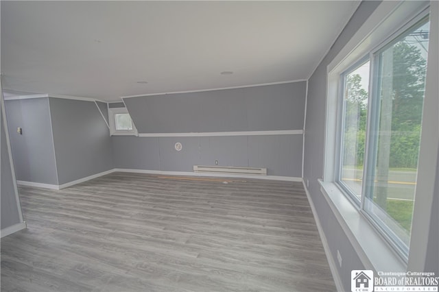 interior space featuring light hardwood / wood-style floors, baseboard heating, and plenty of natural light