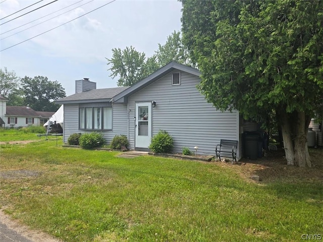 rear view of property featuring a lawn