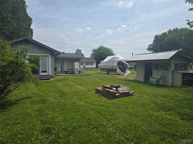 view of yard featuring an outbuilding and a fire pit