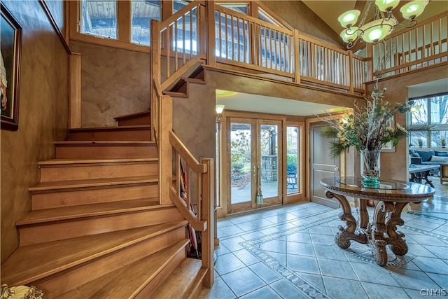 tiled foyer featuring a chandelier, french doors, and a high ceiling