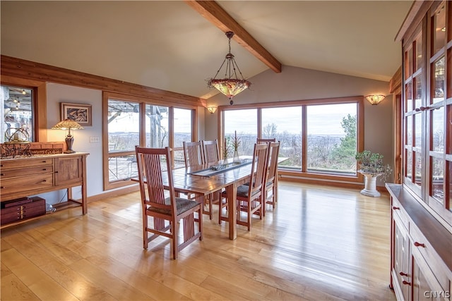 dining space with light hardwood / wood-style floors and lofted ceiling with beams