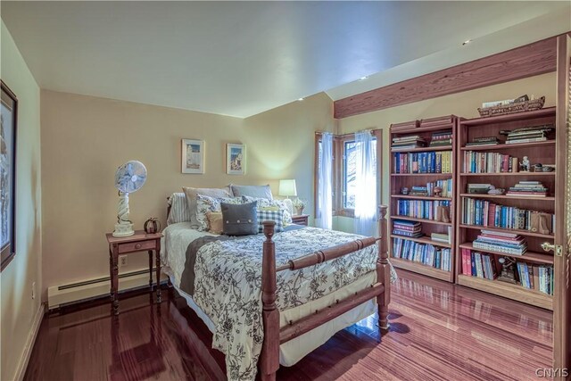 bedroom featuring a baseboard heating unit and dark wood-type flooring